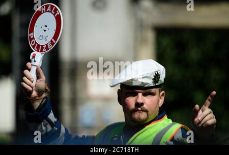 Dresden, Deutschland. Juli 2020. Ein Motorradpolizist winkt bei einer Polizeikontrolle, die prüft, ob bei der Überholung von Radfahrern der Mindestabstand von 1.5 Metern eingehalten wird, einen Polizeikelle zur Seite eines Autofahrers. Mit diesem Sicherheitsprojekt wollen die Polizeidirektion Dresden und der ADFC Sachsen auf die Novellierung der Straßenverkehrsordnung aufmerksam machen, in der spezifische Entfernungsregelungen für Überholungen eingeführt wurden, und die Verkehrsteilnehmer entsprechend sensibilisieren. Quelle: Robert Michael/dpa-Zentralbild/dpa/Alamy Live News Stockfoto