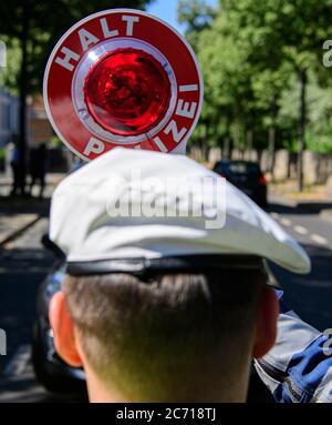 Dresden, Deutschland. Juli 2020. Ein Motorradpolizist winkt bei einer Polizeikontrolle, die prüft, ob bei der Überholung von Radfahrern der Mindestabstand von 1.5 Metern eingehalten wird, einen Polizeikelle zur Seite eines Autofahrers. Mit diesem Sicherheitsprojekt wollen die Polizeidirektion Dresden und der ADFC Sachsen auf die Novellierung der Straßenverkehrsordnung aufmerksam machen, in der spezifische Entfernungsregelungen für Überholungen eingeführt wurden, und die Verkehrsteilnehmer entsprechend sensibilisieren. Quelle: Robert Michael/dpa-Zentralbild/dpa/Alamy Live News Stockfoto
