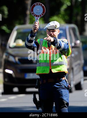 Dresden, Deutschland. Juli 2020. Ein Motorradpolizist winkt bei einer Polizeikontrolle, die prüft, ob bei der Überholung von Radfahrern der Mindestabstand von 1.5 Metern eingehalten wird, einen Polizeikelle zur Seite eines Autofahrers. Mit diesem Sicherheitsprojekt wollen die Polizeidirektion Dresden und der ADFC Sachsen auf die Novellierung der Straßenverkehrsordnung aufmerksam machen, in der spezifische Entfernungsregelungen für Überholungen eingeführt wurden, und die Verkehrsteilnehmer entsprechend sensibilisieren. Quelle: Robert Michael/dpa-Zentralbild/dpa/Alamy Live News Stockfoto