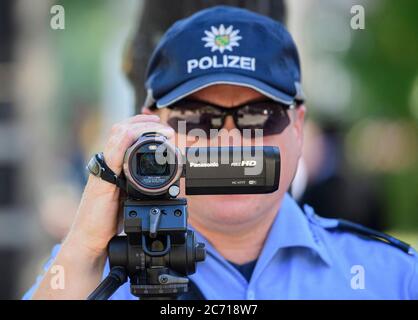 Dresden, Deutschland. Juli 2020. Ein Polizist filmt den Verkehr mit einer Videokamera im Rahmen einer Polizeikontrolle, die prüft, ob bei einem Überholen der Radfahrer die Mindestdistanz von 1.5 Metern eingehalten wird. Mit diesem Sicherheitsprojekt wollen die Polizeidirektion Dresden und der ADFC Sachsen auf die Novelle der Straßenverkehrsordnung aufmerksam machen, in der spezifische Entfernungsregelungen für Überholungen eingeführt wurden, und die Verkehrsteilnehmer entsprechend sensibilisieren. Quelle: Robert Michael/dpa-Zentralbild/dpa/Alamy Live News Stockfoto