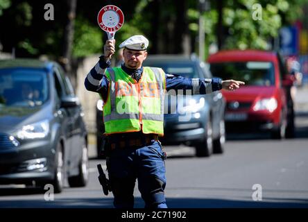 Dresden, Deutschland. Juli 2020. Ein Motorradpolizist winkt bei einer Polizeikontrolle, die prüft, ob bei der Überholung von Radfahrern der Mindestabstand von 1.5 Metern eingehalten wird, einen Polizeikelle zur Seite eines Autofahrers. Mit diesem Sicherheitsprojekt wollen die Polizeidirektion Dresden und der ADFC Sachsen auf die Novellierung der Straßenverkehrsordnung aufmerksam machen, in der spezifische Entfernungsregelungen für Überholungen eingeführt wurden, und die Verkehrsteilnehmer entsprechend sensibilisieren. Quelle: Robert Michael/dpa-Zentralbild/dpa/Alamy Live News Stockfoto