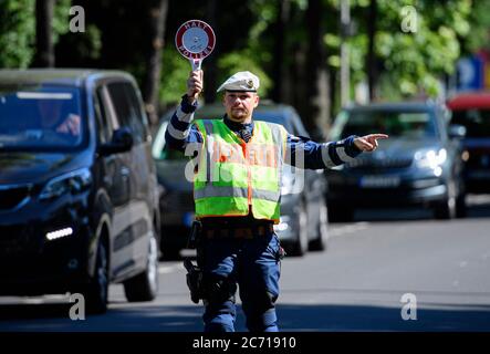Dresden, Deutschland. Juli 2020. Ein Motorradpolizist winkt bei einer Polizeikontrolle, die prüft, ob bei der Überholung von Radfahrern der Mindestabstand von 1.5 Metern eingehalten wird, einen Polizeikelle zur Seite eines Autofahrers. Mit diesem Sicherheitsprojekt wollen die Polizeidirektion Dresden und der ADFC Sachsen auf die Novellierung der Straßenverkehrsordnung aufmerksam machen, in der spezifische Entfernungsregelungen für Überholungen eingeführt wurden, und die Verkehrsteilnehmer entsprechend sensibilisieren. Quelle: Robert Michael/dpa-Zentralbild/dpa/Alamy Live News Stockfoto