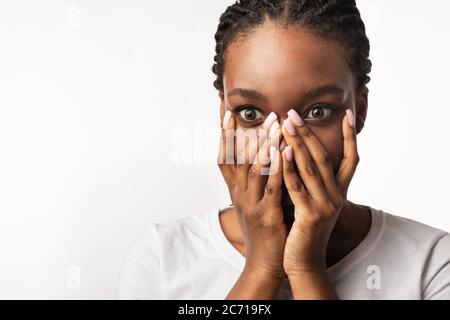 Schockiert Afrikanisches Mädchen Blick Auf Kamera Abdeckung Mund, Weißer Hintergrund Stockfoto