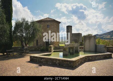 Frontino,Pesaro Urbino,Marche,Italia.Torrione della città e Fontana-scultura di Franco Assetto. Stockfoto