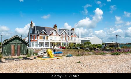 Häuser am Strand, Pevensey Bay, East Sussex, England. Typische Strandhäuser entlang der englischen Küste an der Südküste Englands. Stockfoto