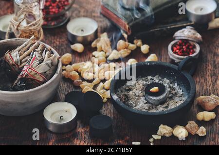 Frieden von Weihrauch Harz Räucherstäbchen Brennen auf Holzkohle als Luftreinigung Zeremonie auf Wiccan Hexenaltar. Gelber Weihrauch im Jemen, Salbei-Schmierstöcke Stockfoto