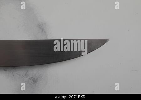 Ein professionelles isoliertes Küchenmesser auf weißem Marmorhintergrund. Küchengeschirr aus Stahl Stockfoto