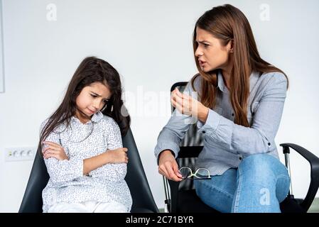 Junge strenge Mutter oder Schwester schimpfen hartnäckige Kind Mädchen. Stockfoto