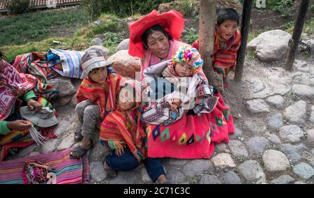 Ollantaytambo, Peru - August 2017: Porträt einer nicht identifizierten peruanischen Frau mit ihren Kindern in der einheimischen Kleidung in Ollantaytambo, Peru Stockfoto