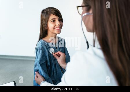 Doktor untersucht ein kleines Mädchen mit Stethoskop. Medizin und Gesundheitswesen Konzept. Stockfoto