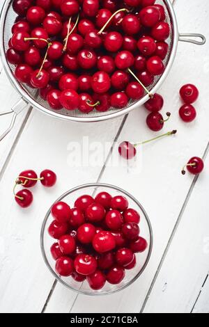 Frische Kirschen auf weißem Holzhintergrund. Stockfoto