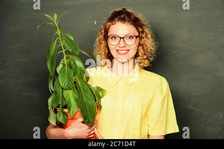 Umweltaktivitäten. Lehrer Frau in Gläsern bei Biologie Lektion. Umweltbildung. Baum der Erkenntnis. glückliche Schüler Mädchen mit Werk in blackboard. Schule Natur studieren. Stockfoto