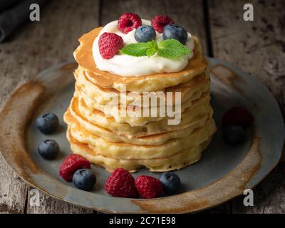 Pfannkuchen mit Vanillecreme, Heidelbeeren und Himbeeren. Seitenansicht, Makro, Nahaufnahme Stockfoto