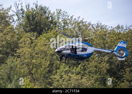 Oppenau, Deutschland. Juli 2020. Ein Polizeihubschrauber fliegt über den Wald in der Nähe der Gemeinde Oppenau. Die Polizei sucht mit einem großen Kontingent nach einem Mann, der am Sonntag, 12.07.2020, bei einem Check in einer Hütte die Dienstwaffen von vier Polizisten genommen hatte. Quelle: Philipp von Ditfurth/dpa/Alamy Live News Stockfoto