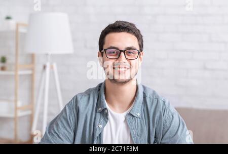 Junger Geschäftsmann, der zu Hause arbeitet. Typ mit Brille im Innenraum Stockfoto