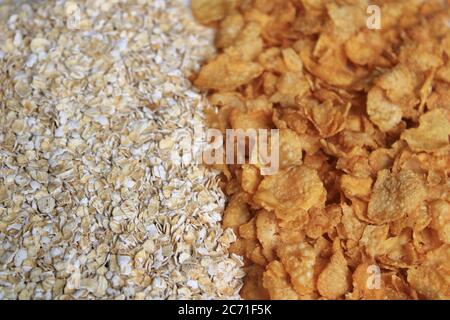 Voller Hafer und Cornflakes. Haferbrei in Getreide und Cornflakes auf weißem Hintergrund. Gesunde Ernährung Konzept-Haferflocken und Cornflakes. Stockfoto