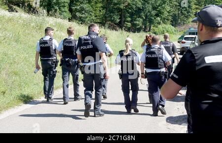 Oppenau, Deutschland. Juli 2020. Polizisten gehen auf einem Weg zu einem nahe Oppenau. Am Tag zuvor hatte ein Mann Polizisten bei einer Inspektion in der Nähe von Oppenau bedroht und entwaffnet und dann geflohen. Ein großes Kontingent sucht den Flüchtenden. (An dpa: "Polizisten in Oppenau entwaffnet - 31-Jähriger noch auf der Flucht") Quelle: Sven Kohls/SDMG/dpa/Alamy Live News Stockfoto