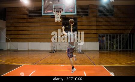 Antalya - Türkei - 17. Oktober 2013: Junger Mann übt Basketball allein in der Arena Stockfoto