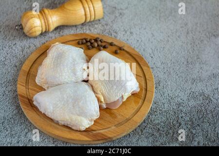Rohe Hähnchenschenkel auf einem Schneidebrett.Kochen. Stockfoto