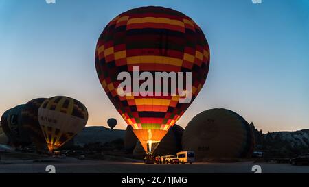 Kappadokien, Türkei - August 2017: Detail eines großen Heißluftballons, der bei Sonnenaufgang für seinen Erstflug aufgeblasen wird. Stockfoto