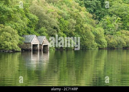 Zwei Bootsschuppen aus Stein und Schiefer auf dem Tiefsee des Llyn Dinas im Snowdonia Nationalpark. Stockfoto