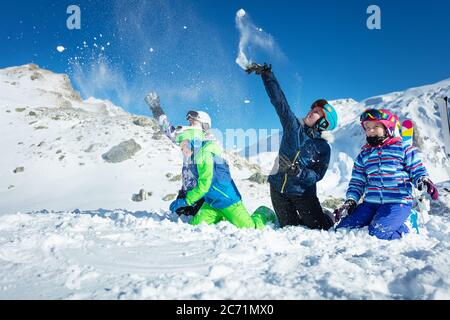 Gruppe von Kindern spielen im Schnee werfen Schneebälle im Ski-Outfit spielen Spaß Spiel zusammen Stockfoto