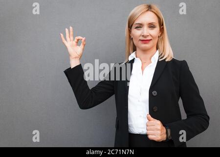 Geschäftsfrau zeigt okay Geste Stockfoto