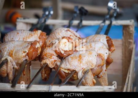 Nahaufnahme der Hühnerbeine auf Spieße aufgereiht und bereit zum Kochen, selektive Fokussierung Stockfoto