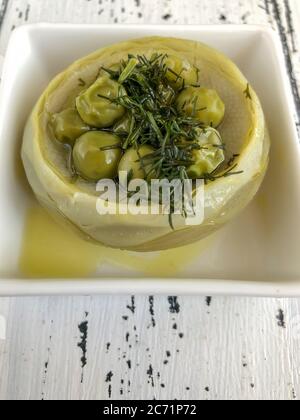 Closeup Artischocke mit Erbsen und Olivenöl auf dem Tisch gekocht Stockfoto