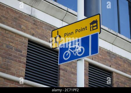 11. Juli 2020 - England, UK: Blaues Radfahrschild unter gelbem Hausschild Stockfoto