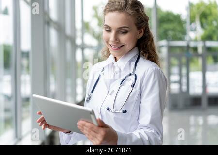 Konzept für Gesundheitswesen, Technologie und Medizin - lächelnde Ärztin mit Stethoskop Notizen am Tablet pc-Computer. Stockfoto