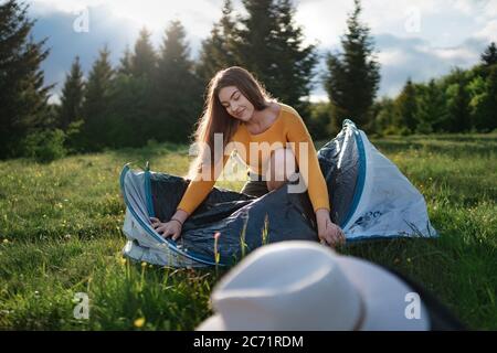 Glückliche junge Frau mit Zelt Schutz im Freien im Sommer Natur. Stockfoto