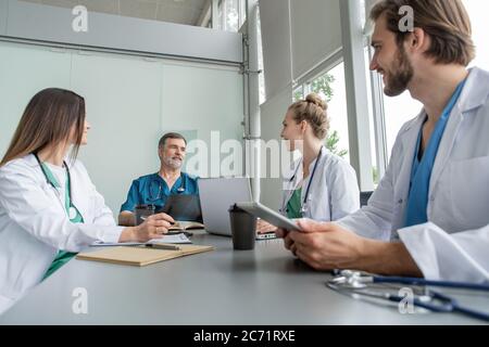 Medizinisches Team Diskutiert Behandlungsoptionen Mit Patienten. Ärzteteam, das im Besprechungsraum eine Besprechung abhalten wird. Stockfoto
