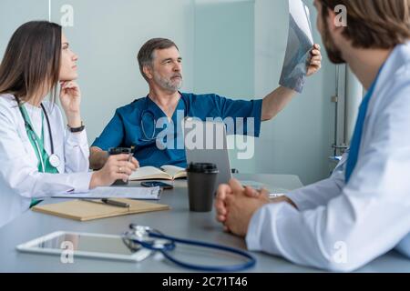 Medizinisches Team Diskutiert Behandlungsoptionen Mit Patienten. Ärzteteam, das im Besprechungsraum eine Besprechung abhalten wird. Stockfoto
