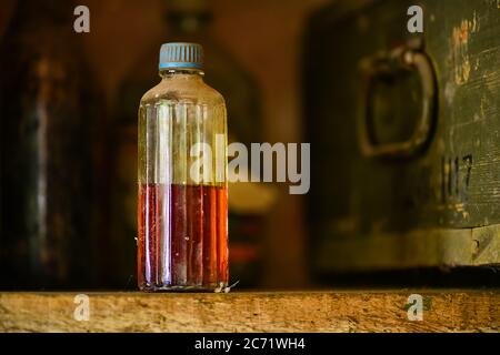 Vintage Nahaufnahme Bild von Stillleben Zusammensetzung, staubige chemische Flasche mit Flüssigkeit auf Holz rack.selective Fokus Schuss Stockfoto