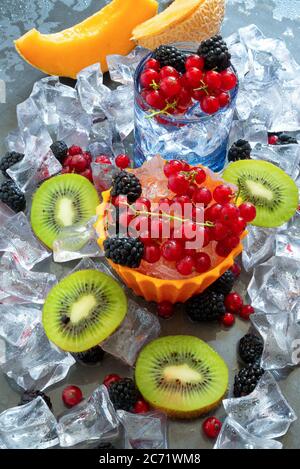 Durstlöschenglas mit kaltem Wasser und frischen Sommerfrüchten mit Eis Stockfoto