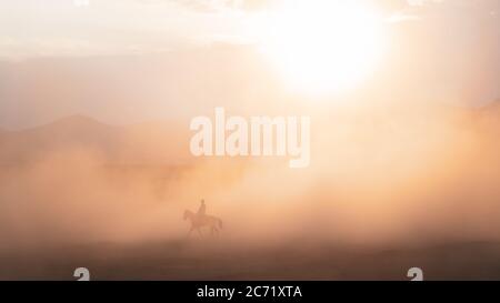 Kayseri, Türkei - November 2019: Nicht identifizierter Mann, der in Staub und Nebel auf einem Pferd reitet Stockfoto