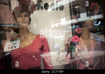 Malaga, Spanien. Juli 2020. Ein Mann mit Gesichtsmaske spiegelt sich in einem Schaufenstergeschäft wider, während Flamenco-Mannequins in einem Geschäft in der Innenstadt zu sehen sind.das Auftreten des neuen Coronavirus (COVID-19) Ausbruch in Spanien nach Lockerung der Beschränkungen hat die Regionalregierung dazu veranlasst, die obligatorische Verwendung von Gesichtsmasken im Freien zu verhängen Orte, auch wenn sie einen sicheren Abstand zwischen Menschen beobachten. Diese Maßnahme versucht, die Ausbreitung der Coronavirus-Pandemie einzudämmen. Kredit: SOPA Images Limited/Alamy Live Nachrichten Stockfoto