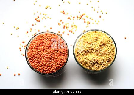 Haufen ungekochte rote Linsen und Taubenerde. Mungbohnen und rote Linsen in zwei Schüsseln isoliert auf weißem Hintergrund. Stockfoto