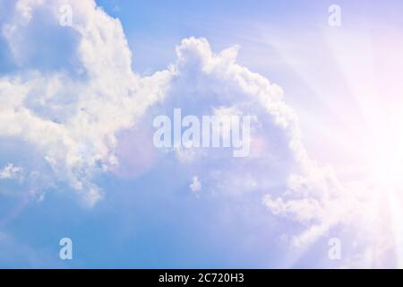 Cumulus Wolken am blauen Himmel und Sonnenstrahlen brechen durch die Wolken. Speicherplatz kopieren Stockfoto