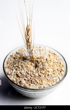 Schüssel voller Hafer. Haferbrei Hafer in Müslischale auf weißem Hintergrund. Eine Schüssel mit ganzen Hafer isoliert auf einem weißen. Gesunde Ernährung Konzept-Haferflocken. Stockfoto