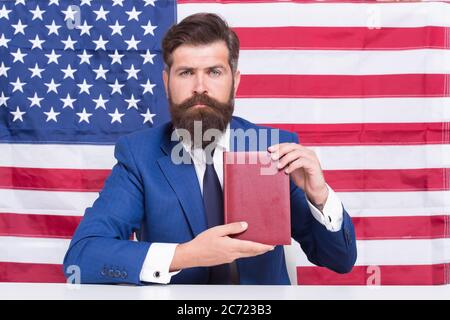 Freiheit des Druckens. Patriotischer Geschäftsmann halten Buch auf amerikanischer Flagge Schwarzboden. Amerikanische Freiheit. Tag der Unabhängigkeit. Juli. Stolz und Freiheit. Politische Rechte und Freiheiten. Freiheit der Wahl. Stockfoto