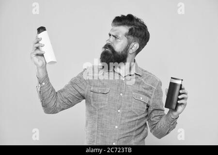 Die Behandlung mit individueller Betreuung. Hipster halten Haar Shampoo und Conditioner gelben Hintergrund. Haar Behandlung. Shampoonieren und Klimaanlage. Bart Behandlung Produkte. Haut Behandlung. Hautpflege. Stockfoto