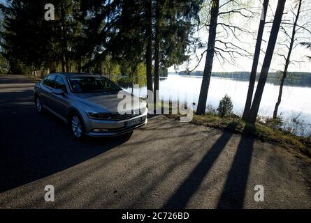 Volkswagen Passat 1.4 tsi Limousine 2015 Modell geparkt am Straßenrand Lay-by an einem See im Sommer , Finnland Stockfoto