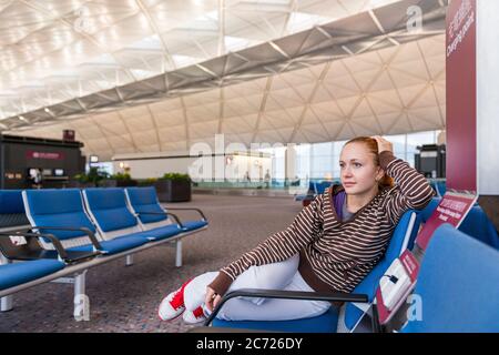 Junge Frau wartet auf ihren Flug Stockfoto