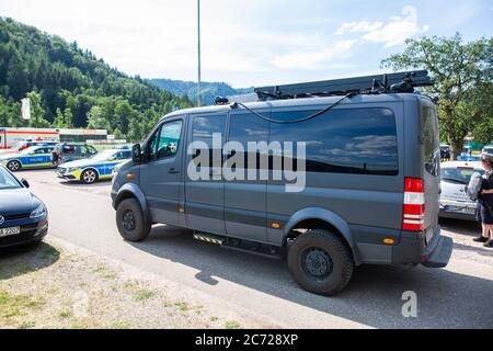 Oppenau, Deutschland. Juli 2020. Ein SEK-Fahrzeug fährt über den Parkplatz eines Sportplatzes, der als Treffpunkt für die Polizei dient. Mit einem großen Kontingent setzte die Polizei am Montag ihre Suche nach einem 31-Jährigen fort, der vier Polizisten in Oppenau im Schwarzwald bedroht und ihnen ihre Dienstwaffen weggenommen hatte. Der Mann, der keinen festen Wohnsitz hat, war nach dem Verbrechen am Sonntagmorgen in den Wald geflohen. Quelle: Philipp von Ditfurth/dpa/Alamy Live News Stockfoto