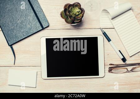 Weißes digitales Tablet auf Holztisch. Flach liegend. Stockfoto