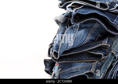 Stapel von verschiedenen Schattierungen von blauen Jeans auf weißem Hintergrund Stockfoto