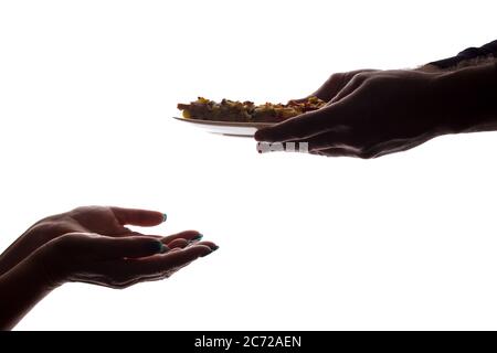 Junger Mann gibt einer älteren Frau in der Hand eine Pizza auf dem Teller - Silhouette, Hilfekonzept Stockfoto