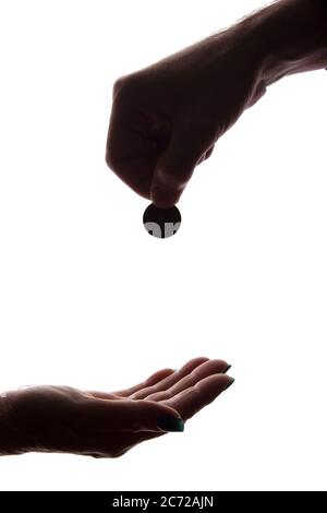 Junge Mann Hand mit einer Münze gibt Almosen - Silhouette, Hilfe Konzept Stockfoto